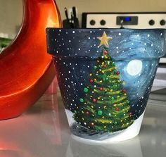 a pot with a christmas tree painted on it