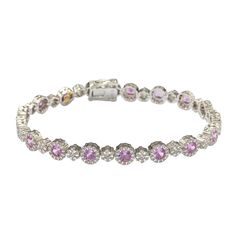 The timeless elegance of this tennis setting converges with rich pink sapphires to create a breathtakingly elegant design. Crafted in sterling silver, round-cut pink sapphires (5.44cttw) are prong set in a halo of created white sapphires (0.96cttw) with created white sapphire flower clusters connecting each sapphire (0.84cttw). 7.24cttw of glistering sapphires embezzle your wrist with this timeless, royal design. Finished with an SL logo and a Suzy Levian Secret Signature brown diamond in the back gallery, this bracelet is designed to encourage women to embrace their own hidden inner beauty as well! Sl Logo, Levian Jewelry, Gemstone Brooch, Cubic Zirconia Bracelet, Cubic Zirconia Jewelry, Jewelry Rings Diamond, Brown Diamond, Gemstone Necklace Pendant, Pink Bracelet