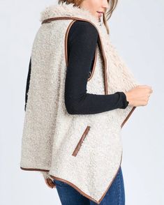 Sherpa vests are always the cutest during fall and winter, especially over a pair of long sleeves, denim jeans, and boots! Take our advice and grab a hold of this vest that features a super soft and cozy wool blend, open front, fold over collar, two functional side pockets, and a faux leather trim. color: beige tone ivory + tan acrylic/wool/polyester blend imported professionally clean Trendy Winter Sweater Vest For Everyday, Trendy Everyday Winter Sweater Vest, Trendy Cotton Vest For Fall, Trendy Sweater Vest For Everyday Fall Wear, Trendy Fall Sweater Vest For Everyday, Fall Vest With Pockets, Sleeveless Outerwear With Faux Fur Lining For Fall, Sleeveless Fall Outerwear With Faux Fur Lining, Fall Sweater Vest With Pockets For Layering