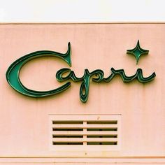 a sign on the side of a building that says capri with stars above it