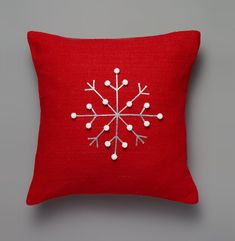 a red pillow with white snowflakes on it