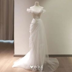 a white wedding dress on display in a room