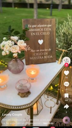 a table with candles and flowers on it in front of a sign that says, you are