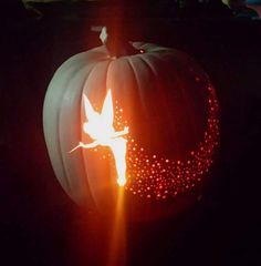 a carved pumpkin with an image of a bird on it's face in the dark