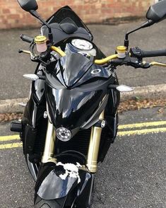 a black motorcycle parked on the street next to a brick building