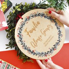 two hands holding up a personalized christmas ornament on top of a table