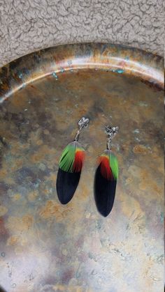 Real Feather earrings featuring a striking combination of red and green macaw parrot feathers and black goose feathers.  Earrings will delight the ladies who prefer shorter accessories. Amazing gift for mom. You can buy these feather earrings as gift for her. These feather earrings are cool for your everyday look. U will love it. The perfect Boho accessory for summer festivals and events. Perfect for parties, birthday gifts, wedding, fancy dress.  Earrings may vary slightly from photos, but will Multicolor Feather Earrings For Gift, Multicolor Feather Earrings Gift, Bohemian Black Feather Earrings, Green Macaw, Feathers Earrings, Wedding Fancy, Dress Earrings, Parrot Feather, Macaw Parrot