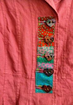 a pink shirt with buttons on it and a colorful tie hanging from the front pocket