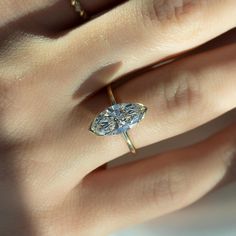 a woman's hand with a ring on it and a diamond in the middle