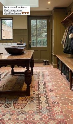 a room with a large rug and wooden table