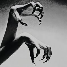 a black and white photo of two hands reaching towards each other with their fingers extended