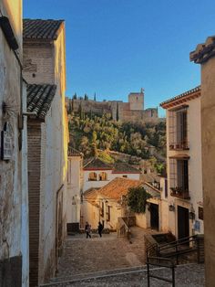 an alley way with buildings and people walking down it