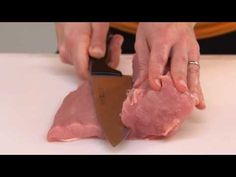 a person cutting meat with a large knife