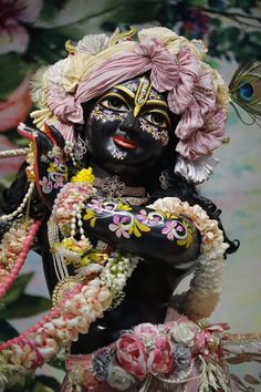 the statue is decorated with flowers and feathers