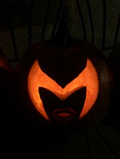 a carved pumpkin with an evil face on it's side in the dark,