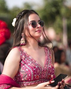 a woman in a pink dress holding a cell phone