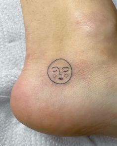 a small tattoo on the foot of a person with a smiley face drawn on it