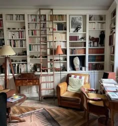 a living room filled with lots of furniture and bookshelves next to a window