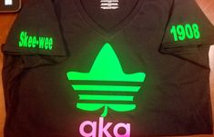 a black shirt with neon green and pink letters on the front, along with an aka t - shirt