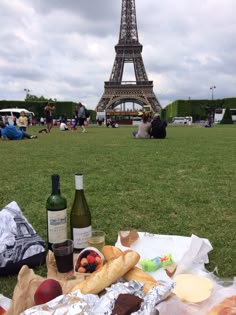 the eiffel tower is in the background with food and wine