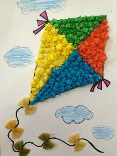 a kite made out of colored paper on top of a sheet of paper with flowers and clouds in the background