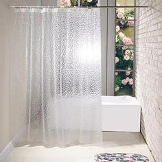 a bathroom with a white shower curtain next to a bath tub