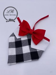 a black and white checkered dog bandana with a red bow