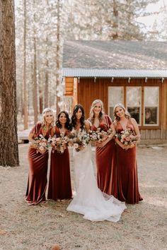 a group of women standing next to each other in front of a cabin with flowers