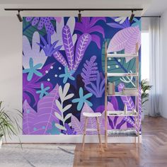 a purple and blue wall mural with tropical leaves on it in a living room setting