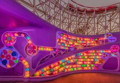 the inside of a carnival ride with colorful lights on it's walls and ceiling