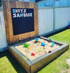 a sandbox with toys in it and the words indy's sandbox written on it