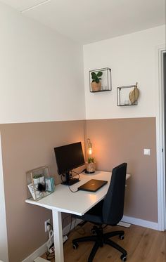 a desk with a computer on top of it in front of a wall mounted clock