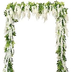 white flowers and greenery are arranged in an arch