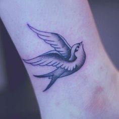 a small bird tattoo on the ankle