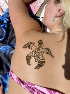 a woman laying down with a tattoo on her back