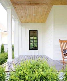 a wooden rocking chair sitting on top of a porch