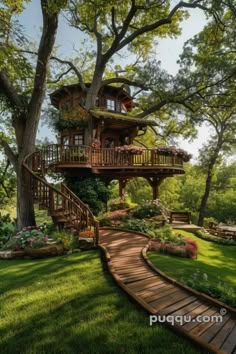 a tree house in the middle of a lush green field with stairs leading up to it