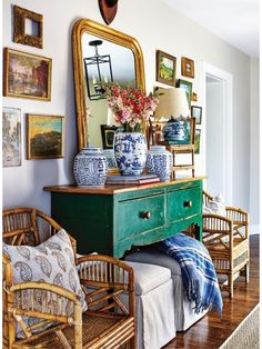 a green dresser with blue and white vases sitting on top of it next to a mirror