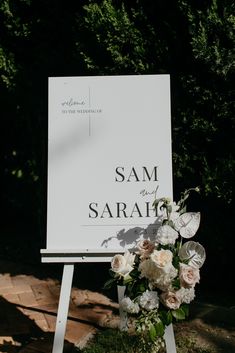 a sign that says sam and sarah with flowers on it in front of some trees