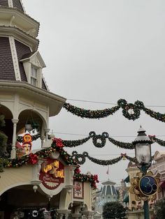 christmas decorations adorn the front of a building in disney world's main street