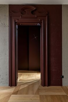 an empty room with wooden floors and red walls