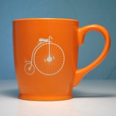 an orange coffee cup with a bicycle drawn on it