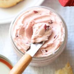 a jar filled with whipped cream next to cookies