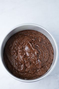 a bowl filled with chocolate cake batter on top of a white countertop next to a knife