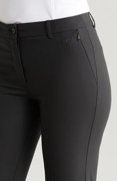 the back view of a woman's black pants with zippers and buttons on them