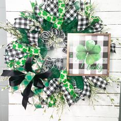 a st patrick's day wreath with green and black plaid bow, shamrocks