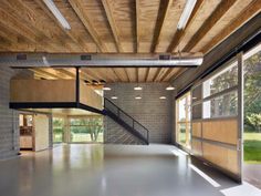 an empty room with large windows and wood ceilinging on the walls, along with concrete floors