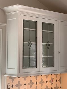 a kitchen cabinet with two glass front doors