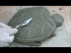 someone is making a turtle out of cement