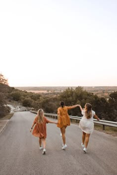 three women walking down the road holding hands